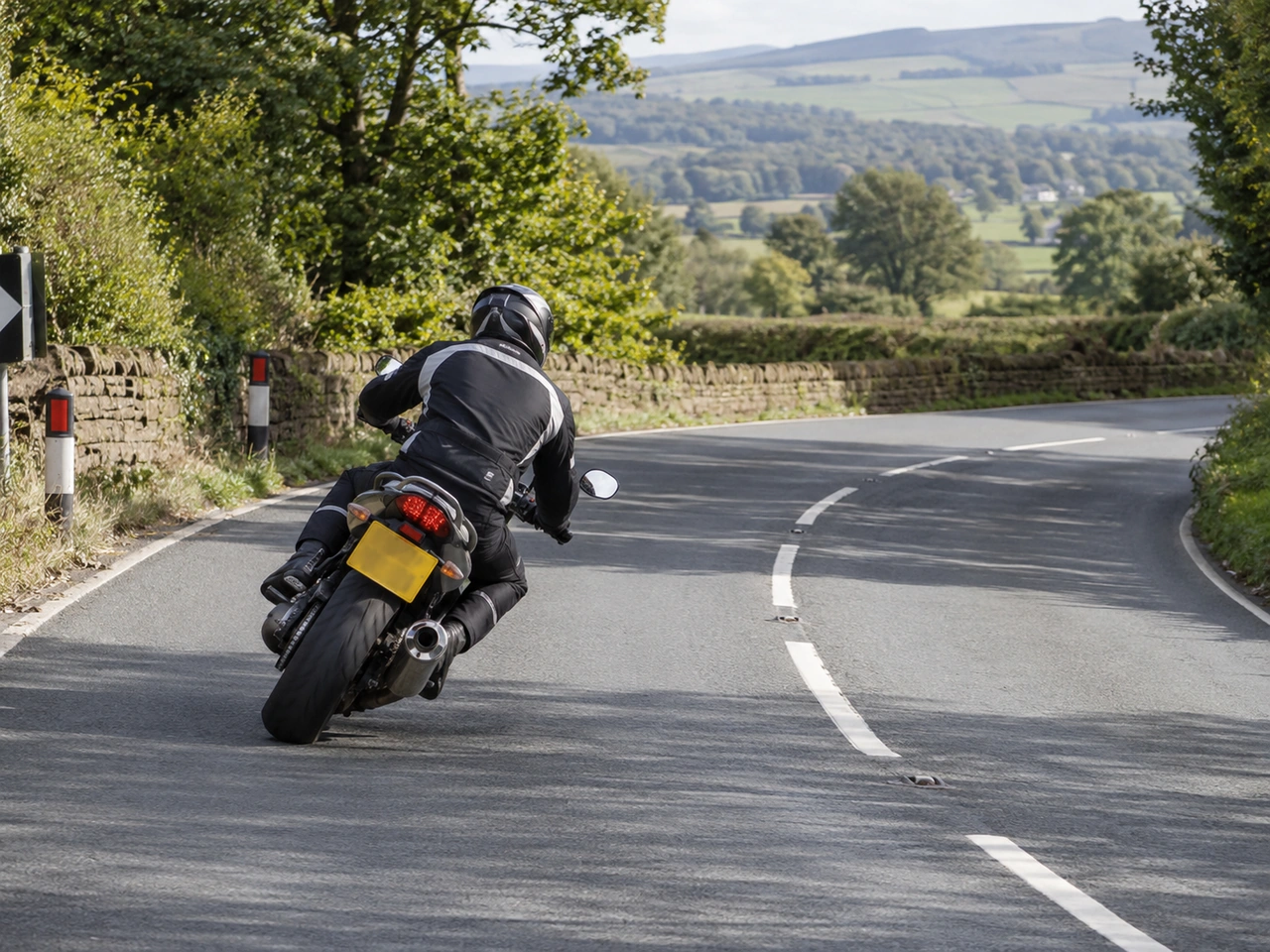 Why should hard braking be avoided while a motorcycle is leaning in a bend?