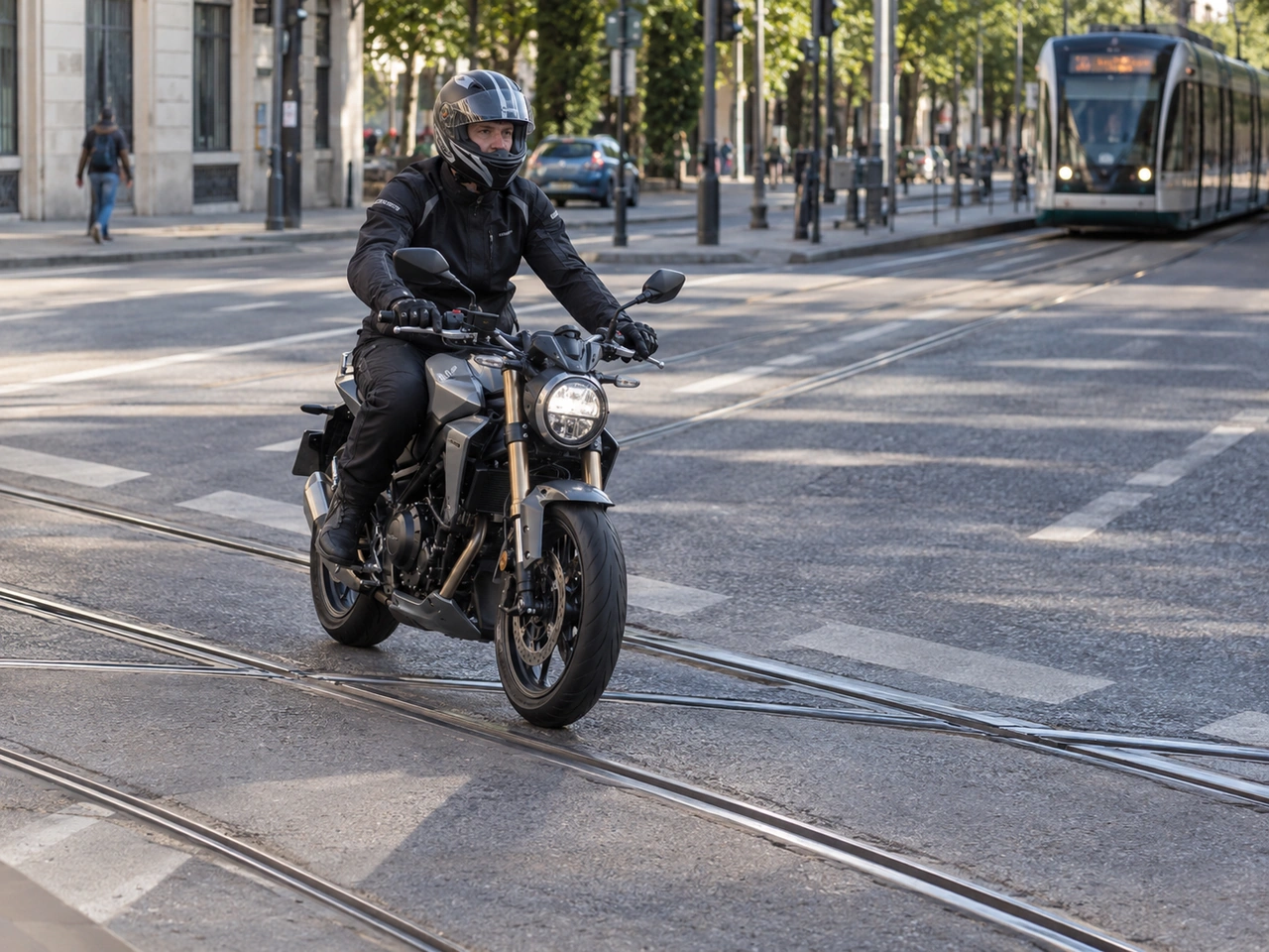 How should a motorcyclist cross tram or railway rails?