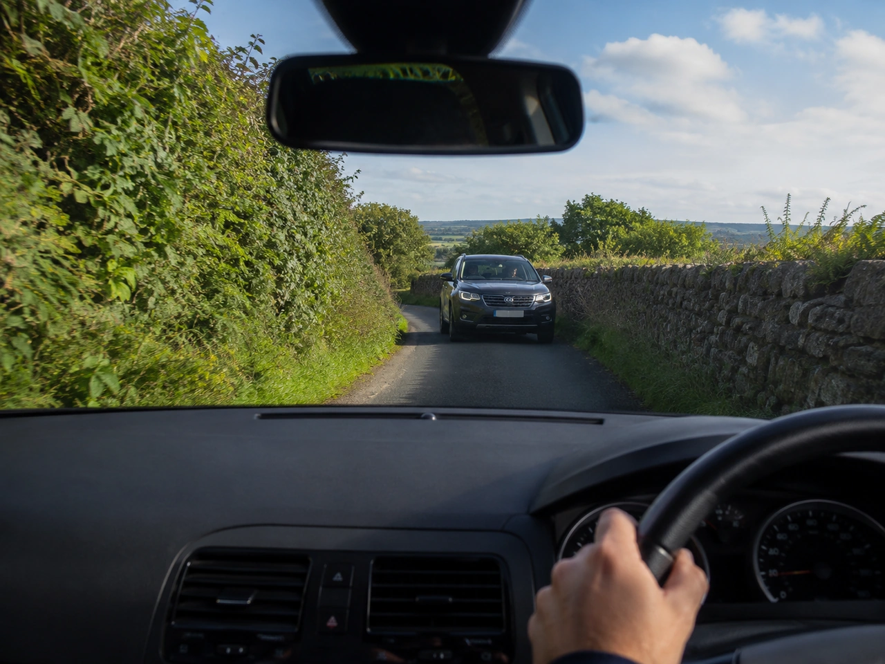 What should you do when approaching a narrow road with oncoming traffic?