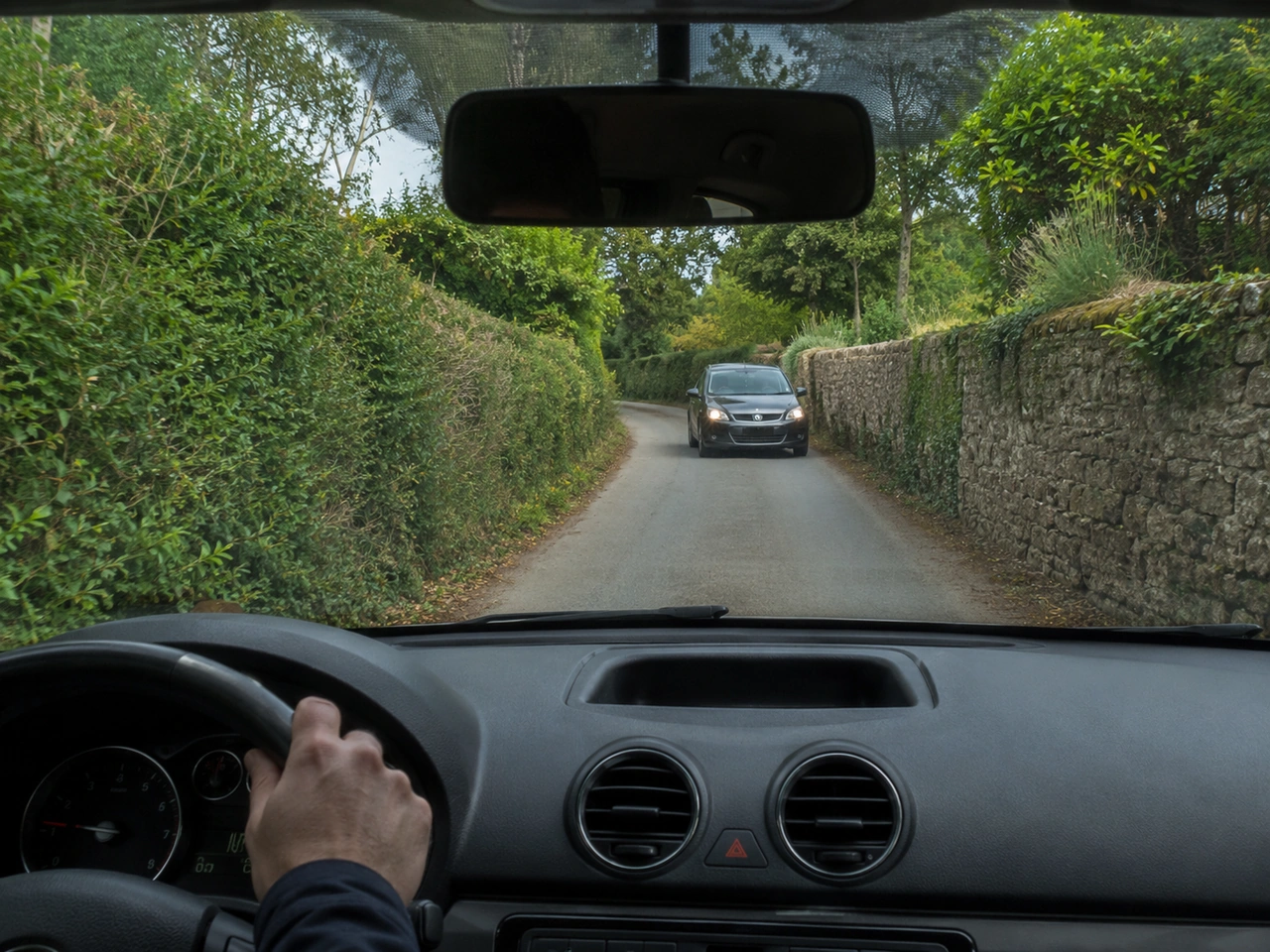 What should you do when approaching a narrow road with oncoming traffic?