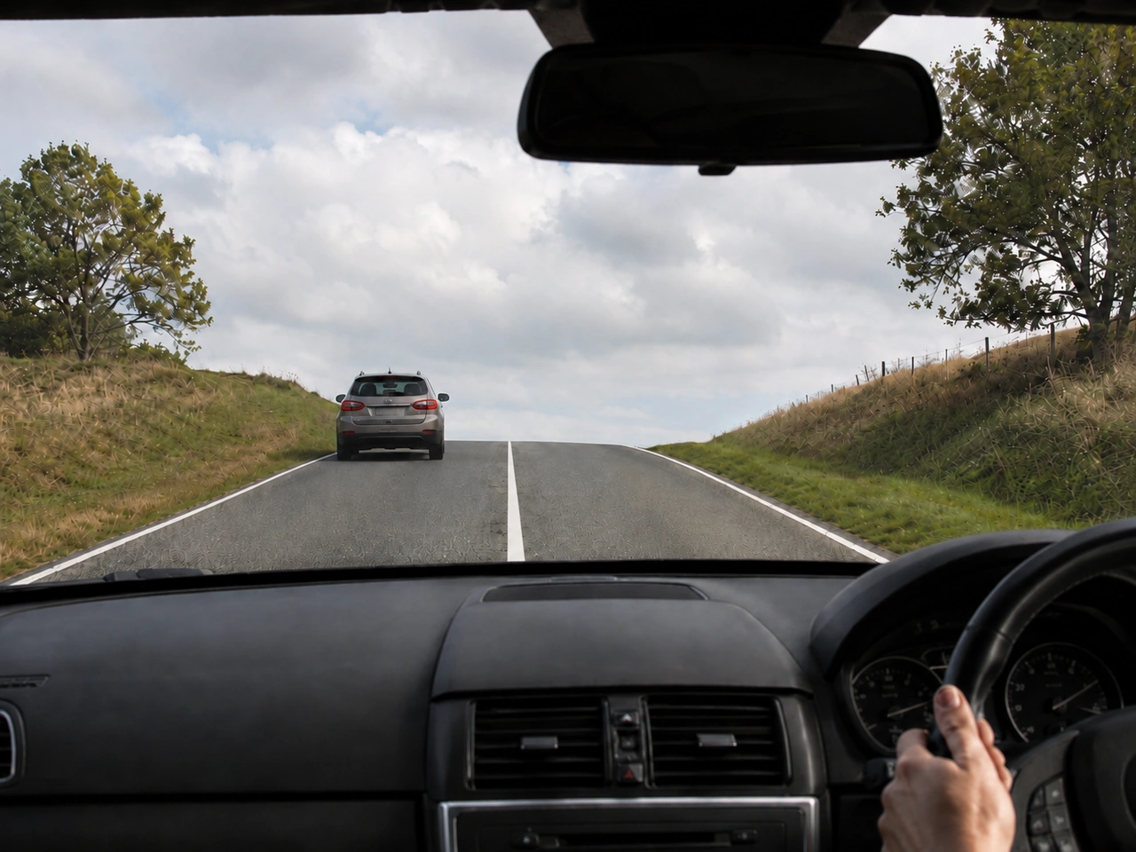 Why should you not overtake near the top of a hill?
